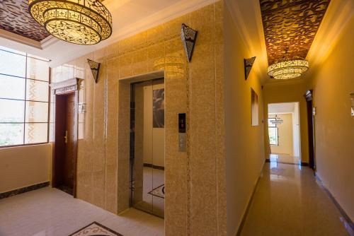 桑给巴尔金色郁金香桑给巴尔度假酒店的走廊设有瓷砖墙壁和灯饰天花板
