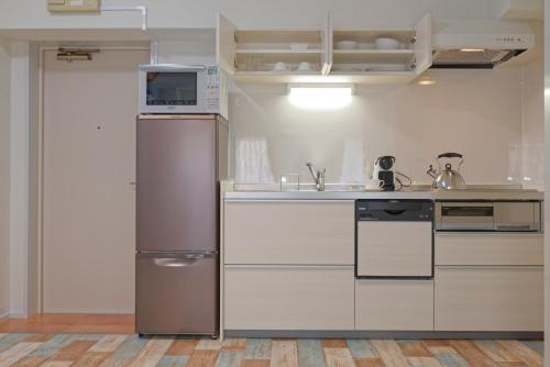 川口市袋鼠之家酒店的厨房配有冰箱和水槽