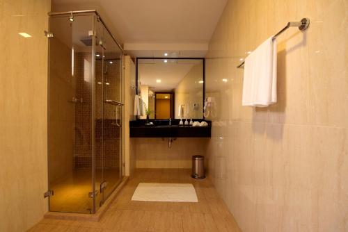 马累查姆帕中央酒店的一间带玻璃淋浴和水槽的浴室