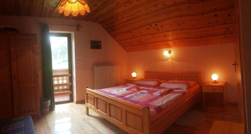 索尔察瓦Farm Stay Juvanija的一间设有一张床铺的卧室,位于一个拥有木制天花板的房间
