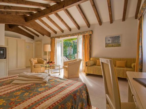 阿斯科纳塔玛洛酒店的一间卧室设有一张床和一间客厅。