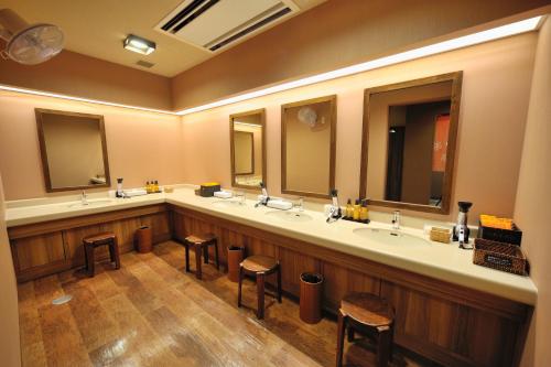 郡山多美迎EXPRESS郡山酒店的一间带三个水槽和两个凳子的大浴室