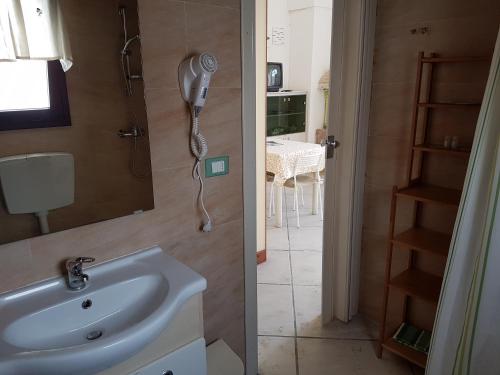 韦列Casavacanze Salento Spani的一间带水槽的浴室和墙上的一部电话
