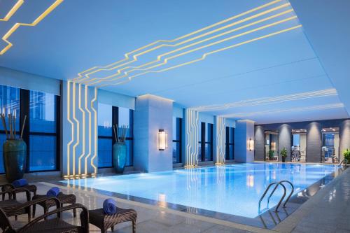荆州荆州富力万达嘉华酒店的一座带椅子的大型游泳池