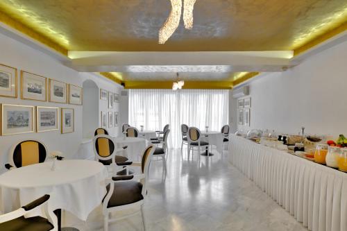 特里波利斯Anaktorikon Boutique Hotel的一间设有白色桌椅的餐厅和一间酒吧
