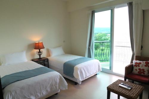 台东安达露西亚的酒店客房设有两张床和窗户。