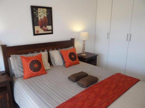 马盖特Arabella No. 2的一间卧室配有一张带橙色枕头的大床