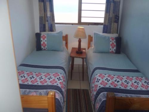 马盖特Villa Siesta Flat No 5的客房设有两张床和一张带台灯的桌子。