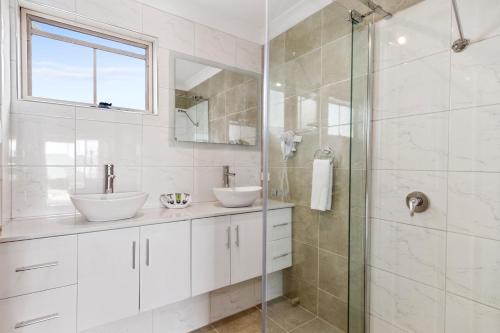斯旺西Swansea Cottages & Lodge Suites的一间带两个水槽和玻璃淋浴间的浴室