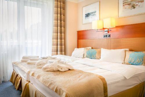 卡罗维发利玛特酒店的酒店客房,配有两张带毛巾的床