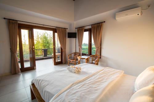 坎古潘德寄宿家庭式酒店的一间卧室配有一张床,阳台配有窗户