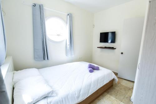 埃拉特Villa Or - Heated Pool的卧室配有白色的床和紫色枕头