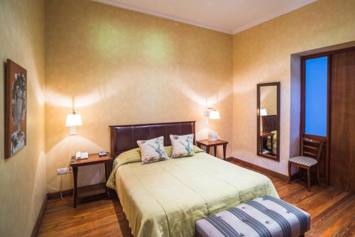 查克拉斯德科里亚塔皮斯俱乐部酒店的一间卧室配有床、两张桌子和镜子
