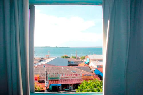 圣塔伦Grand Center Hotel的窗户享有建筑和大海的景致。