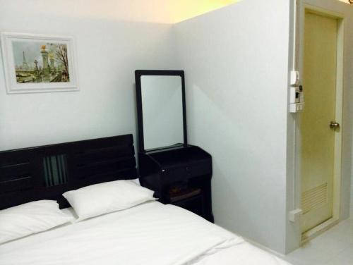 曼谷Bann Bunga Inn的卧室配有一张床,墙上设有镜子