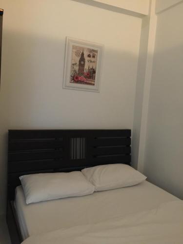 曼谷Bann Bunga Inn的卧室内的一张床铺,墙上挂着一幅画