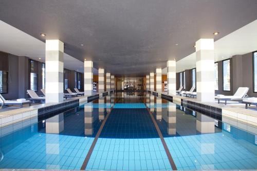 威勒比Lancemore Mansion Hotel Werribee Park的大楼内带桌椅的大型游泳池