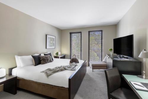 威勒比Lancemore Mansion Hotel Werribee Park的一间卧室配有一张床、一张书桌和一台电视。