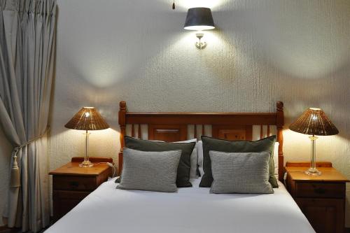 雾观Kruger Park Lodge Unit No. 543的一间卧室配有一张带两张台灯的床铺。