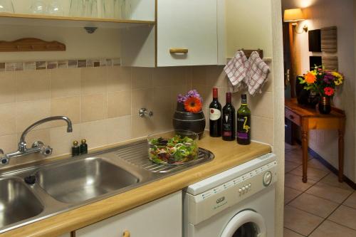 雾观Kruger Park Lodge Unit No. 543的厨房配有水槽、一碗沙拉和葡萄酒瓶