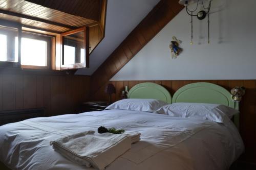 罗卡拉索Number 51的一间卧室配有一张带白色床单和绿色床头板的床。