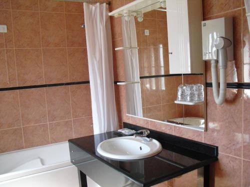科维良索内弗酒店的浴室配有盥洗盆、镜子和浴缸