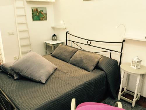 卡塔尼亚镇中之家公寓的一间卧室配有一张带灰色毯子的床和两张桌子