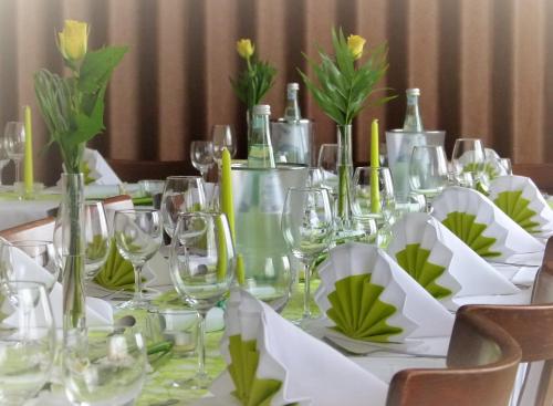 克罗伊茨塔尔Landgasthof & Hotel "Merje"的一张桌子,上面放着酒杯和鲜花