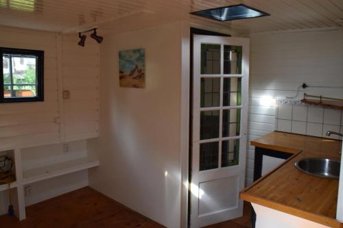 鹿特丹Boat-Apartment Rotterdam Fokkelina的厨房设有白色的墙壁、水槽和柜台。