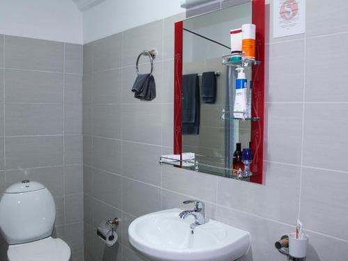 基加利5瑞士酒店的一间带卫生间、水槽和镜子的浴室