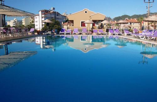 马尔马里斯Reis Maris Hotel的蓝色的大泳池,带紫色躺椅