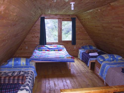 圣赫拉多德多塔格查尔山谷小屋的小木屋内的房间设有两张床和一个窗户