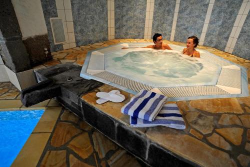 布里尤德拉萨皮涅尔酒店的两个男人在游泳池的按摩浴缸里