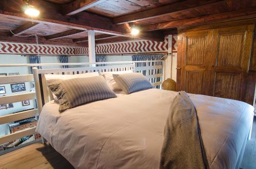 奥梅尼亚B&B Chocolat au lac的木制天花板的客房内的一张大床