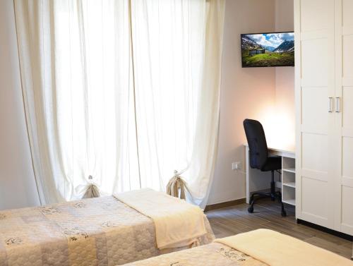 特拉莫Villa Lidia Teramo的一间卧室设有两张床、一张桌子和一个窗口。