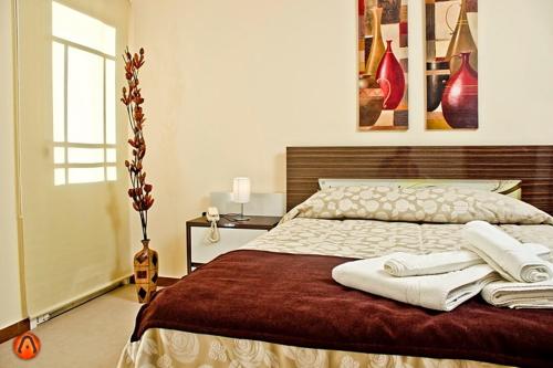皮里亚波利斯Hotel Esmeralda的一间卧室配有一张大床和两条毛巾