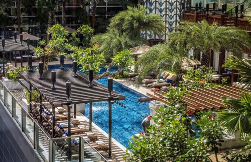 雅加达雅加达四季酒店的一个带躺椅的游泳池和一个度假村