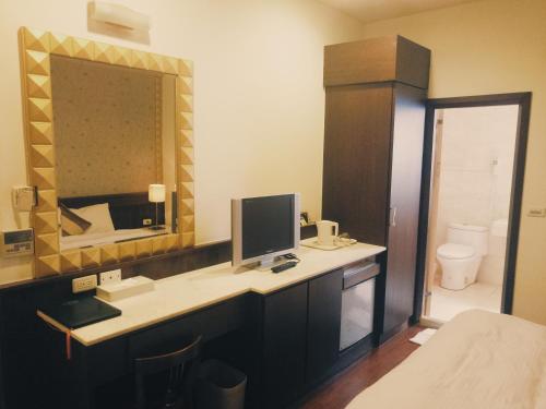 礁溪玉泉旅館的浴室设有一张带电脑和镜子的书桌