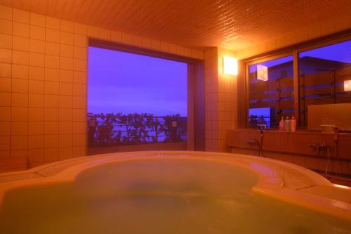 冰见市永芳阁酒店的带窗户的浴室设有大浴缸