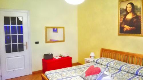 阿斯蒂Luna del Belvedere的卧室配有一张床,墙上挂有绘画作品
