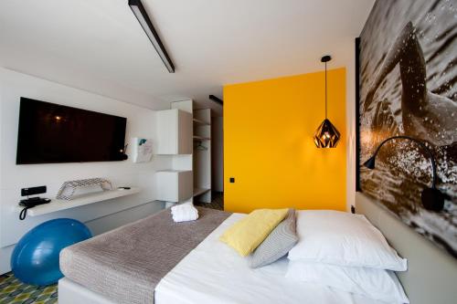 奥托亚克克尔卡温泉运动酒店 的一间卧室配有一张黄色墙壁的床
