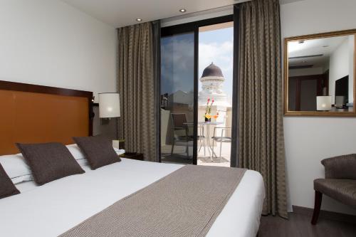 巴塞罗那巴尔莫勒尔酒店的酒店客房设有一张床和一个大窗户
