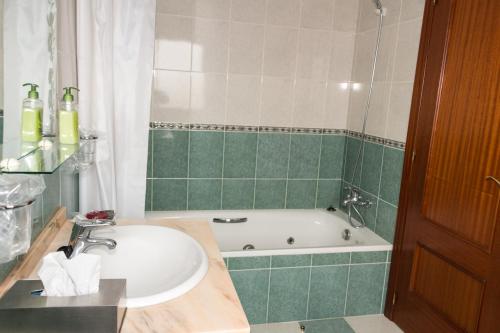 比利亚丹戈斯德尔帕拉莫Hotel Avenida III的浴室配有盥洗盆和浴缸。
