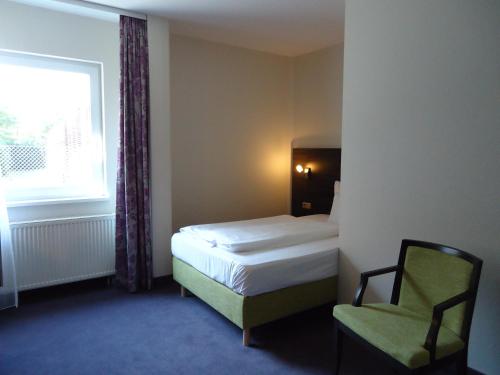 汉诺威MSR汉诺威酒店的卧室配有床、椅子和窗户。