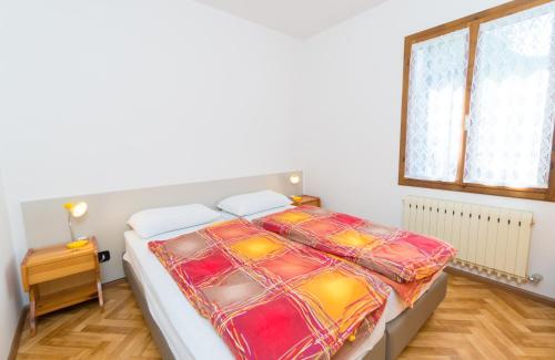 皮耶韦迪莱德罗Casa Luisella的一间卧室配有一张带五颜六色棉被的床