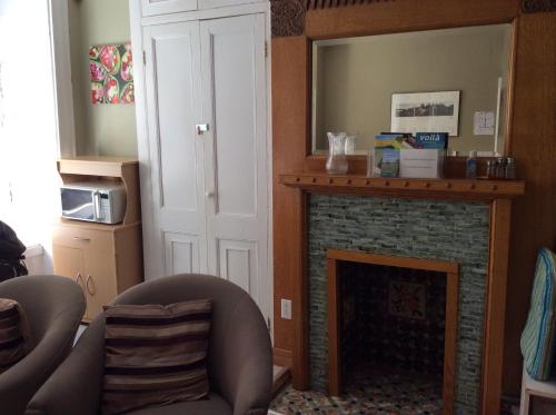 魁北克市奥伯格圣路易斯酒店的客厅设有壁炉和镜子