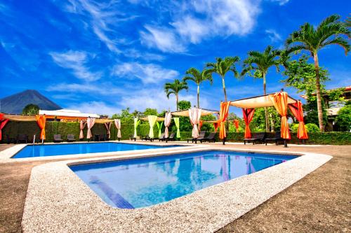 福尔图纳San Bosco Inn的一个带遮阳伞和棕榈树的游泳池