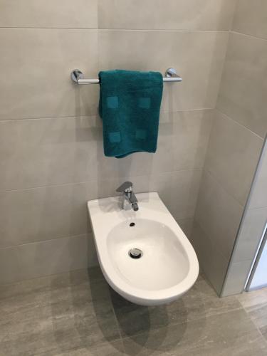 梅拉诺Fürstenstein的浴室设有白色水槽和绿毛巾。