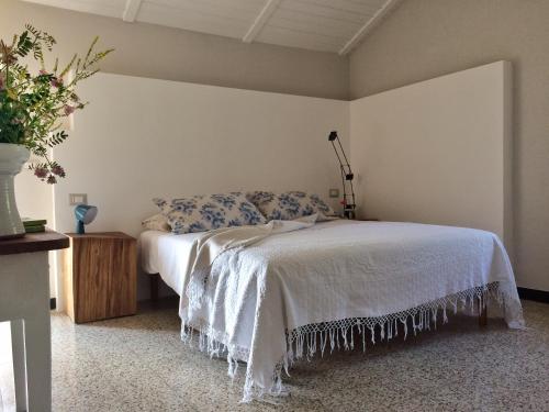MillesimoI Calleri Garden and Rooms的一间卧室,配有一张床和花瓶