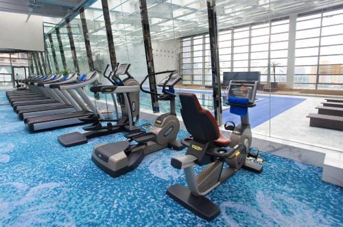 北京北京朝阳悠唐皇冠假日酒店的健身房设有一排健身自行车和游泳池